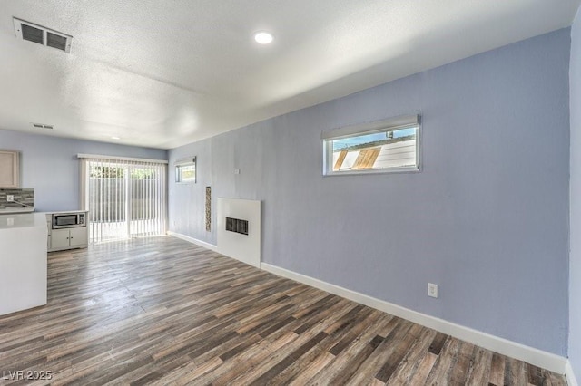 417 Wisteria Ave, Las Vegas, NV 89107 - unfurnished living room featuring dark wood-style floors and a textured ceiling