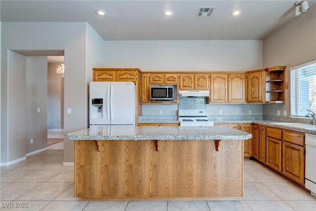 3684 Mooncrest Cir, Las Vegas, NV 89129 - kitchen with white appliances, under cabinet range hood, a kitchen island, open shelves, and light tile patterned floors