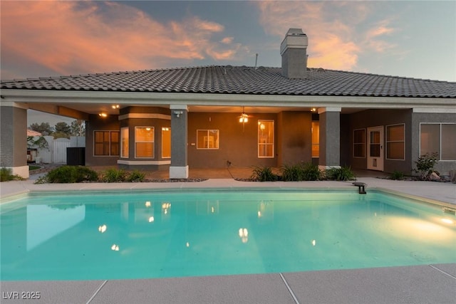 3684 Mooncrest Cir, Las Vegas, NV 89129 - rear view of house featuring a tile roof, a chimney, stucco siding, and an outdoor pool