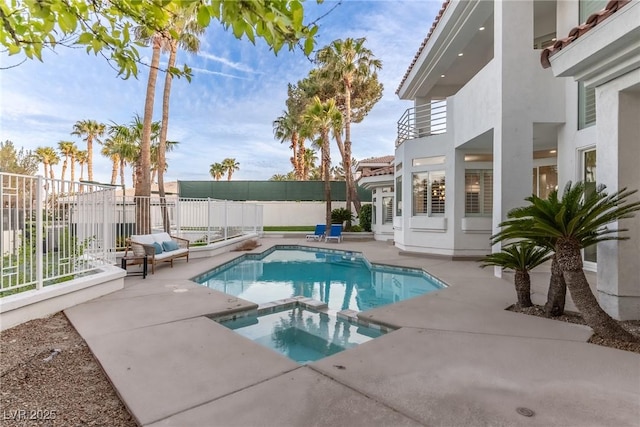 view of pool featuring a patio, a pool with connected hot tub, and a fenced backyard