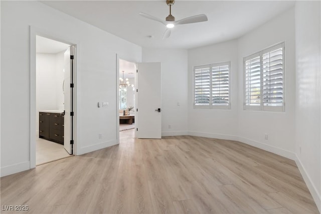 unfurnished bedroom with baseboards, light wood finished floors, and ensuite bath