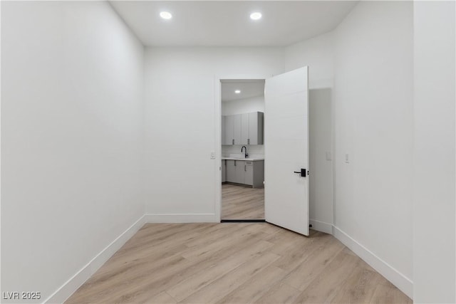 spare room with recessed lighting, light wood finished floors, and baseboards