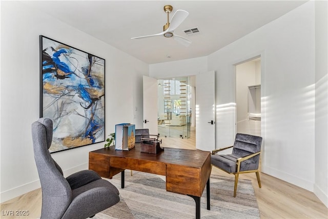 office space featuring visible vents, light wood-style flooring, ceiling fan, and baseboards