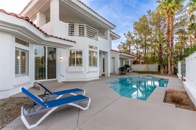 back of property featuring a fenced backyard, a tile roof, a patio area, and stucco siding