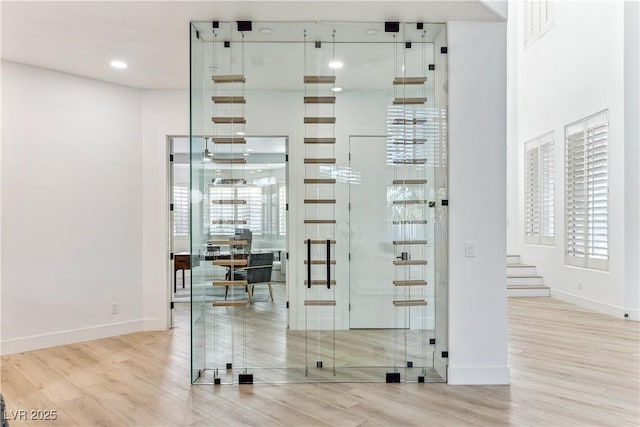 wine area with baseboards, a wealth of natural light, and wood finished floors