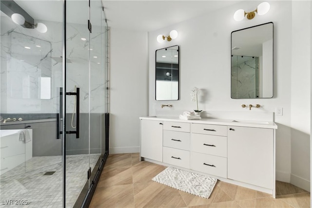 full bath featuring baseboards, double vanity, a marble finish shower, and a sink