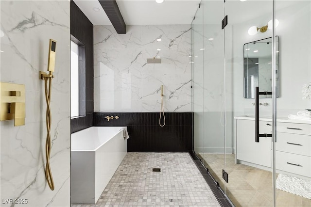 bathroom with a marble finish shower, vanity, and a tub to relax in