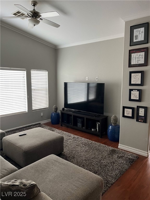 living room featuring baseboards, ornamental molding, a ceiling fan, and wood finished floors