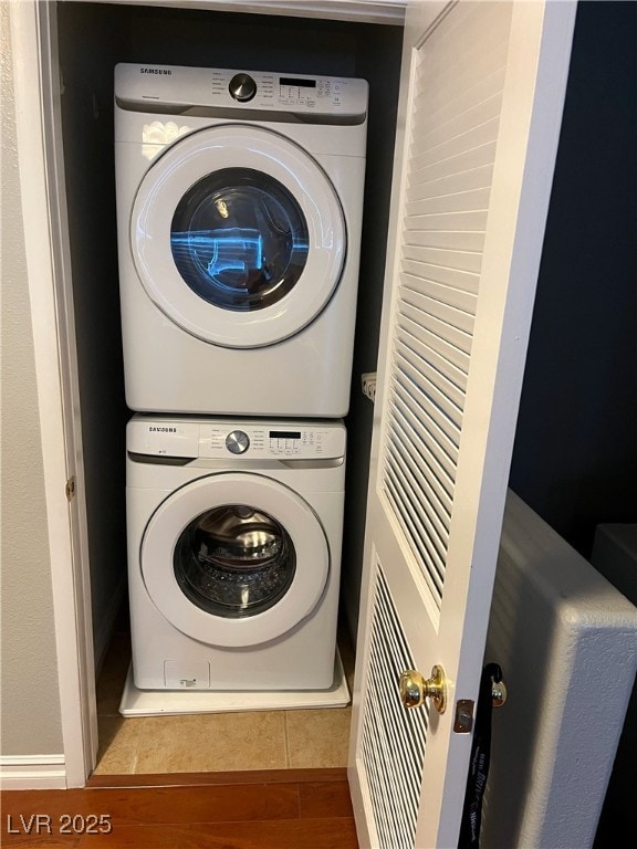 washroom featuring stacked washer / dryer and laundry area