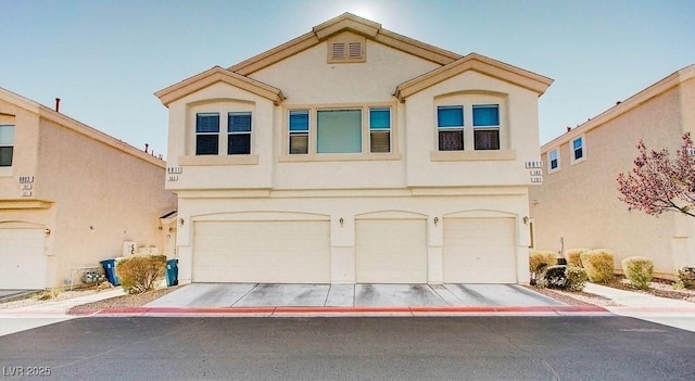 view of front facade with a garage, stucco siding, and concrete driveway