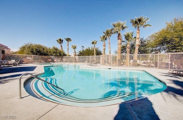 community pool with fence and a patio area