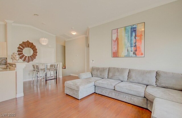 8811 Tomnitz Ave Unit 101, Las Vegas, NV 89178 - living area featuring crown molding, vaulted ceiling, light wood-style floors, a chandelier, and baseboards