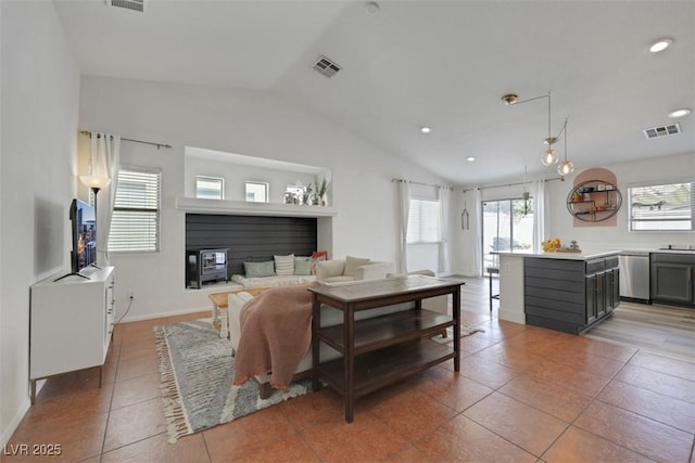 living room with visible vents, light tile patterned floors, and vaulted ceiling