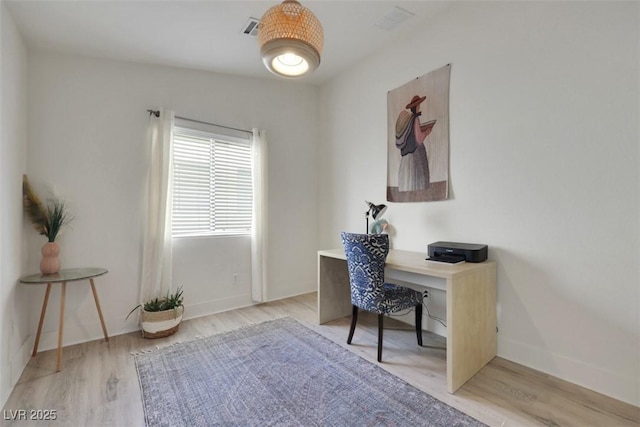 home office featuring light wood-style floors, visible vents, and baseboards