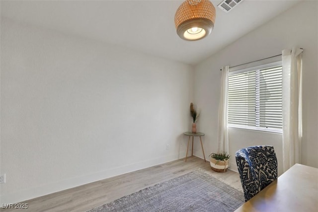 interior space with lofted ceiling, visible vents, wood finished floors, and baseboards