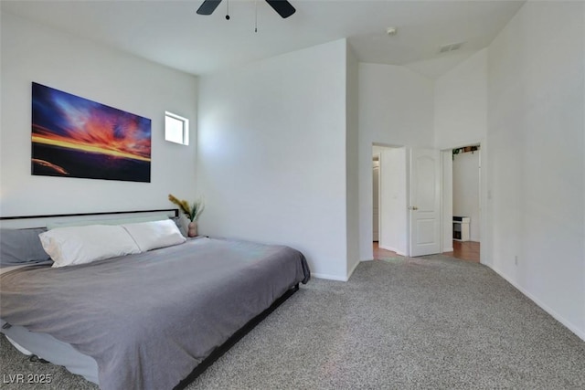 carpeted bedroom with baseboards, visible vents, ceiling fan, and a high ceiling