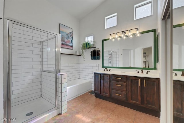 full bathroom featuring a garden tub, a stall shower, double vanity, and a sink