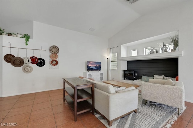 living area with tile patterned flooring, vaulted ceiling, and baseboards