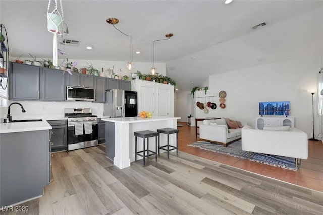 kitchen with gray cabinets, visible vents, stainless steel appliances, and a sink