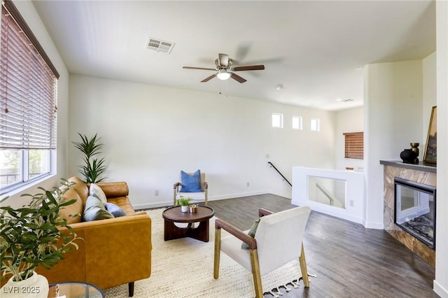 9966 Mystic Moss St, Las Vegas, NV 89183 - living area featuring visible vents, ceiling fan, a high end fireplace, baseboards, and wood finished floors