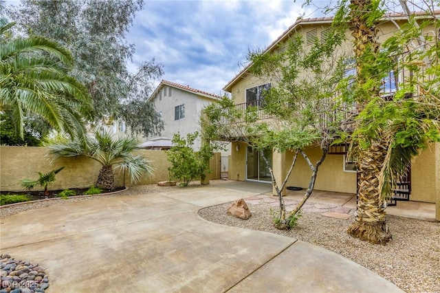 9966 Mystic Moss St, Las Vegas, NV 89183 - rear view of house with stucco siding, fence, a patio area, and a balcony