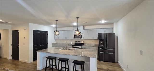 314 W Winston Ln, Indian Springs, NV 89018 - kitchen with a kitchen breakfast bar, a sink, wood finished floors, and stainless steel appliances