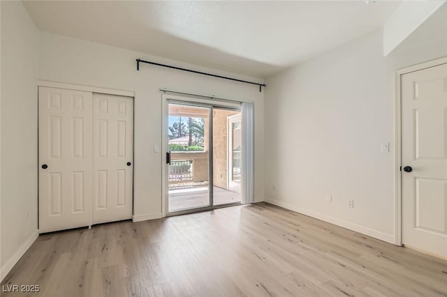 empty room featuring light wood finished floors and baseboards