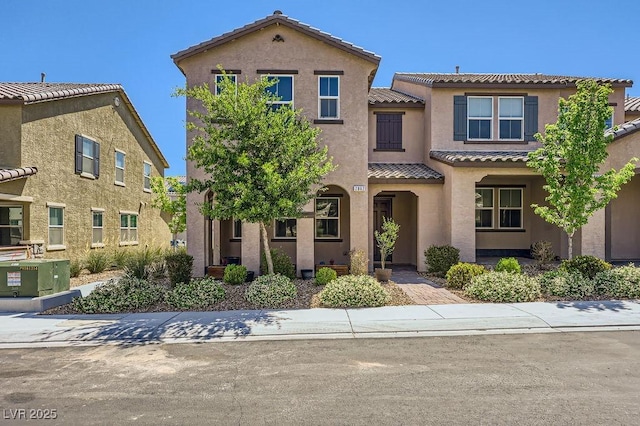 view of front facade featuring a tiled roof and stucco siding