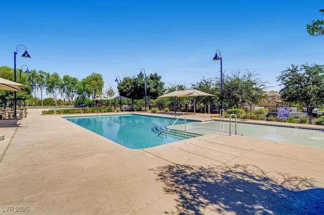 community pool with fence and a patio