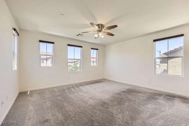 carpeted empty room featuring ceiling fan and baseboards