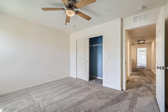unfurnished bedroom featuring attic access, carpet floors, a closet, and baseboards