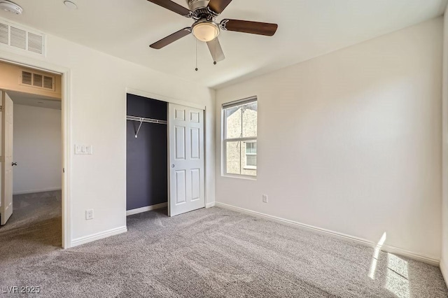 unfurnished bedroom with carpet floors, a closet, baseboards, and a ceiling fan