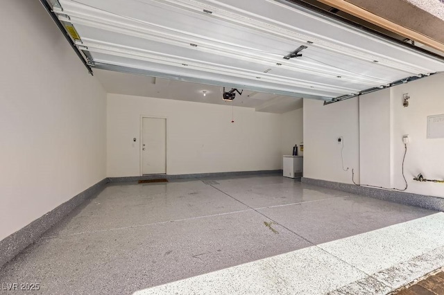 garage with a garage door opener and baseboards