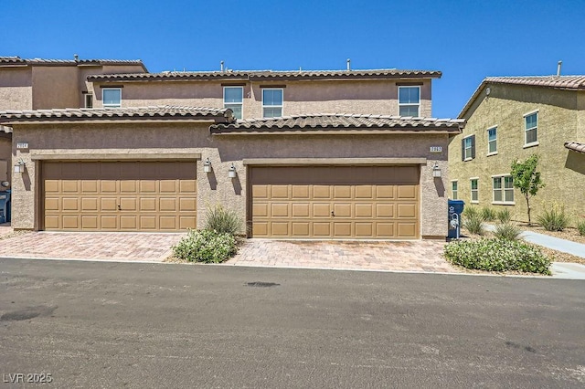 multi unit property with decorative driveway and stucco siding