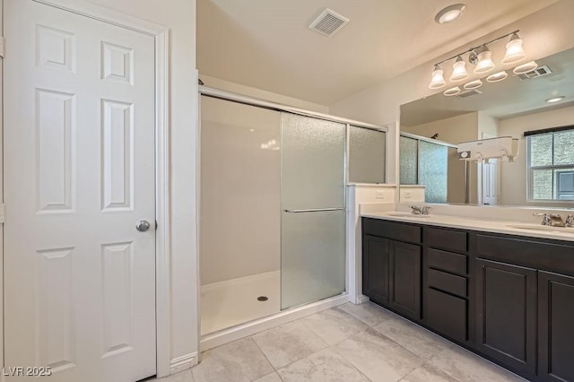 bathroom featuring a stall shower, double vanity, and tile patterned floors