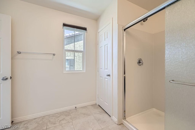 full bath with a shower stall and baseboards