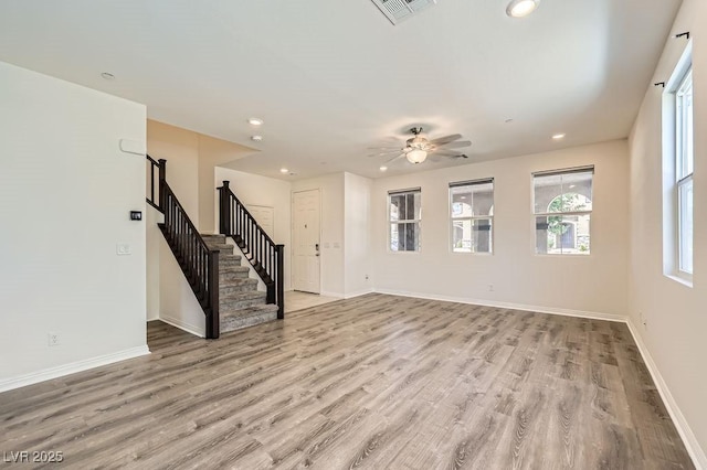unfurnished living room with stairs, light wood-style flooring, recessed lighting, baseboards, and ceiling fan