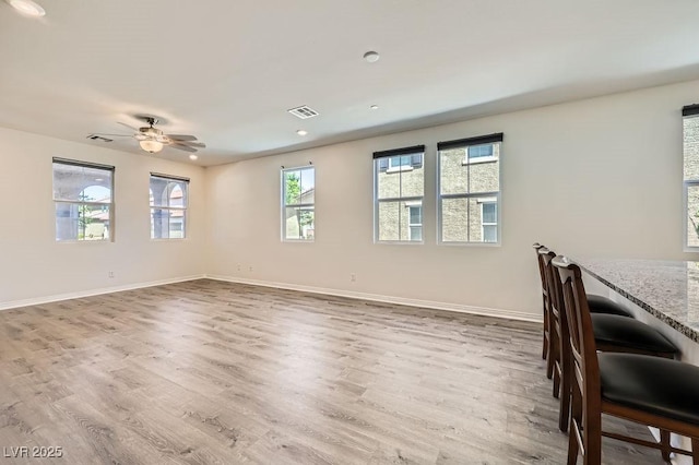 unfurnished dining area with wood finished floors, a ceiling fan, baseboards, and recessed lighting