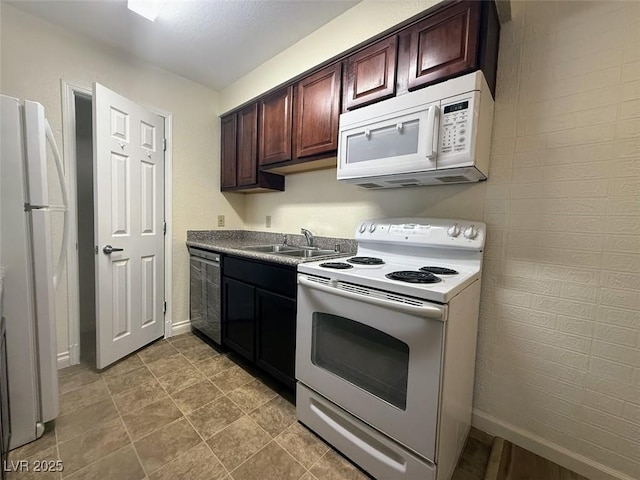 kitchen with dark brown cabinets, white appliances, baseboards, and a sink