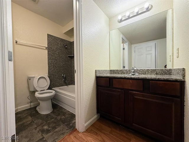 full bathroom with toilet, vanity,  shower combination, and baseboards