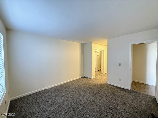 carpeted empty room featuring baseboards