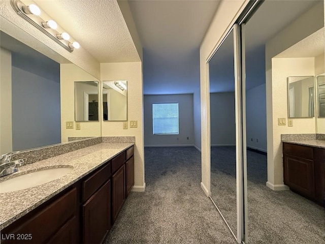 bathroom with baseboards, carpet floors, and vanity