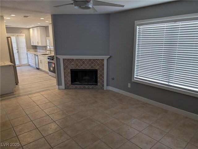 2716 Knightsbridge Rd, Henderson, NV 89074 - unfurnished living room featuring recessed lighting, a tile fireplace, light tile patterned floors, ceiling fan, and baseboards