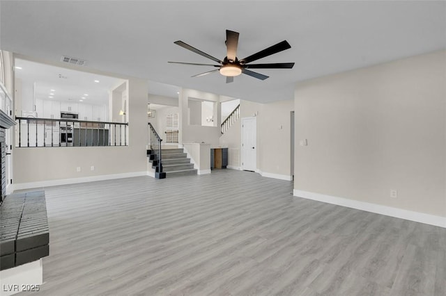 8232 Ocean Terrace Way, Las Vegas, NV 89128 - unfurnished living room featuring stairway, visible vents, a ceiling fan, and light wood-style floors