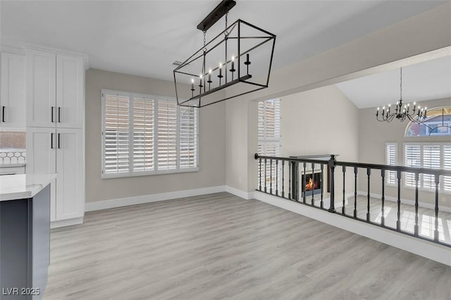 8232 Ocean Terrace Way, Las Vegas, NV 89128 - unfurnished dining area featuring light wood finished floors, a notable chandelier, and baseboards