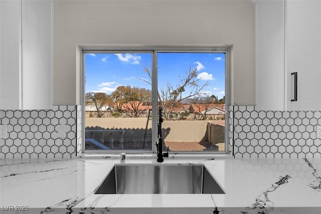 8232 Ocean Terrace Way, Las Vegas, NV 89128 - details with light stone countertops, a sink, white cabinetry, and tasteful backsplash