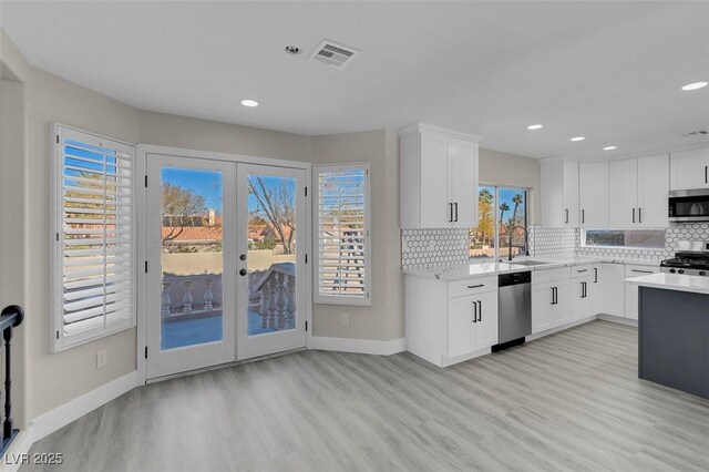 8232 Ocean Terrace Way, Las Vegas, NV 89128 - kitchen with a sink, appliances with stainless steel finishes, visible vents, light countertops, and light wood finished floors