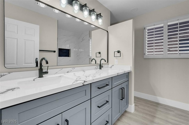 8232 Ocean Terrace Way, Las Vegas, NV 89128 - bathroom featuring a sink, double vanity, a shower, baseboards, and wood finished floors