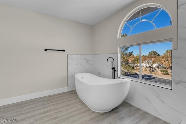 8232 Ocean Terrace Way, Las Vegas, NV 89128 - bathroom featuring tile walls, a freestanding bath, and wood finished floors
