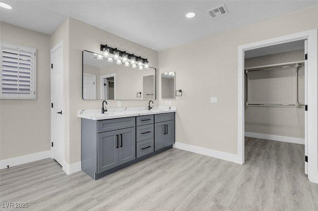 8232 Ocean Terrace Way, Las Vegas, NV 89128 - bathroom featuring double vanity, wood finished floors, recessed lighting, and baseboards